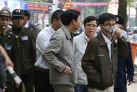 Human rights lawyer Le Quoc Quan (3rd R, with glasses) stands with a Catholic priest and believers near security personnel before he is arrested by police during Cu Huy Ha Vu's trial in Hanoi April 4, 2011. Vu, a legal scholar who sued Vietnam's prime minister and called for an end to one-party rule, was sentenced on Monday to seven years in prison in one of the Communist country's most important political trials in years. The Hanoi People's Court convicted Vu, the 53-year-old son of a Vietnamese revolutionary leader, of spreading propaganda against the state. Police detained human rights lawyer Le Quoc Quan and pro-democracy activist Pham Hong Son who were among about two dozen supporters congregating outside the courthouse, witnesses said. REUTERS/Stringer (VIETNAM - Tags: POLITICS CRIME LAW)