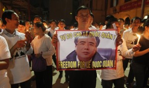 A man holds a poster with the image of lawyer Le Quoc Quan during a mass calling for Quan to be freed at Thai Ha church in Hanoi on September 29, 2013. © 2013 Reuters