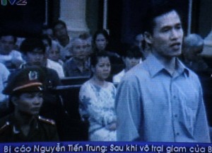 A TV grab taken on Vietnam TV Channel 2 shows Nguyen Tien Trung (R), 26, standing during his trial at Ho Chi Minh City People's Court House, Jan. 20, 2010.