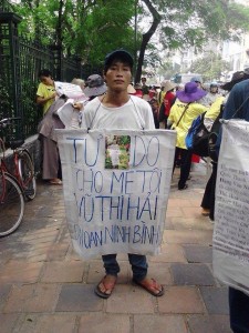 Mr. Tuyen with banner demanding for his mother release at a demonstration in Hanoi