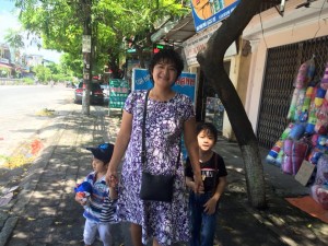 Ms. Nga and her two sons Tai and Phu near her rent house in Phu Ly