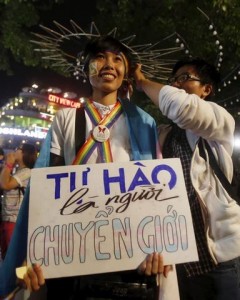 A participant holds a placard which reads "proud to be transgender" as they wait for an LGBT demonstration along a street in Hanoi. (c) 2015 Reuters