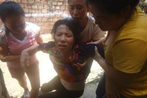 Tran Thi Hong is helped by friends after a tortuous encounter with Vietnamese authorities.