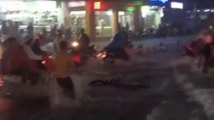 Nhiều xe máy bị cuốn vào dòng nước, trong một clip người đàn ông đuổi theo chiếc xe máy bị trôi đi