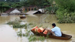 Một người đàn ông chèo thuyền vận chuyển hàng cứu trợ giúp các nạn nhân lũ lụt ở huyện Hương Khê, Hà Tĩnh. (Ảnh tư liệu)