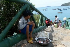 Trẻ em địa phương ven biển miền Trung Phú Yên bán đồ lưu niệm san hô khô cho khách du lịch hôm 1/8/2016.