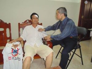 Photo: Bác sỹ Đinh Đức Long khám bệnh cho lính biên giới Trần Bang, sau khi anh này bị hành hung vì biểu tình phản đối chuyến đi Việt Nam của Tập Cận Bình năm 2015.