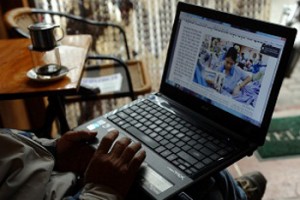 Một người đàn ông đang đọc tin tức trên mạng với chiếc laptop của mình tại một tiệm cà phê ở trung tâm Hà Nội ngày 15/1/2013.
