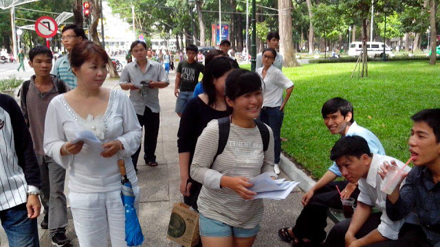 Rights activist Nguyen Hoang Vi distributing Universal Declaration of Human Rights to people on May 5 at April 30 park. © Dan Lam Bao 2013