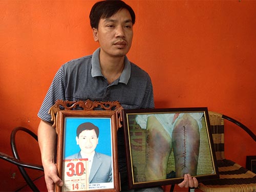 Người thân cầm ảnh ông Nguyễn Mậu Thuận tại phiên tòa sơ thẩm Ảnh: ĐỖ DU