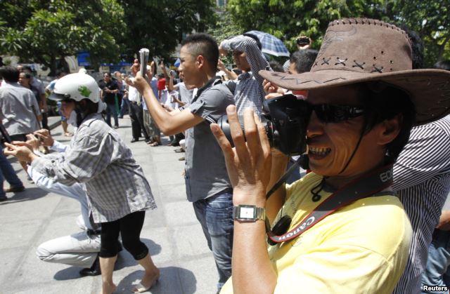 FILE - Blogger JB Nguyen Huu Vinh (front) takes photos while attending an anti-China protest in Hanoi.