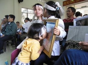 A daughter of Ngo Thanh Kieu and his family at a trial against police officers-petretrators